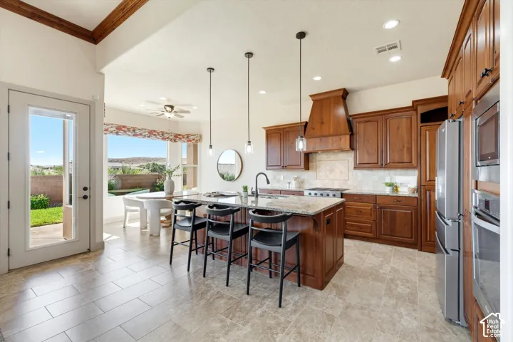 Gourmet kitchen with wood cabinetry, stainless steel appliances, granite countertops, and a large center island