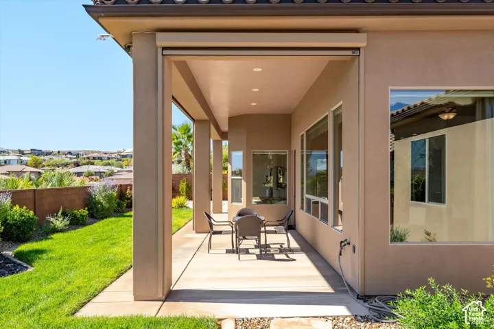 Expansive covered patio with recessed lighting, stucco exterior, and multiple large windows