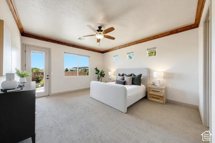Spacious primary bedroom showcasing a coffered ceiling with wood trim detailing, ceiling fan with integrated lighting, and abundant natural light from multiple windows