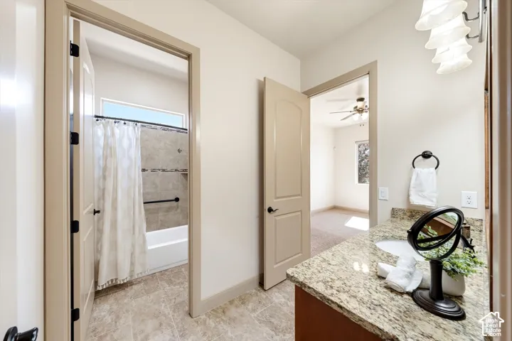 Bathroom featuring a vanity with granite countertop, undermount sink, and tiled flooring