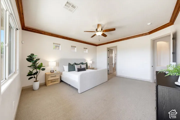 Spacious room featuring vaulted ceilings with wood-finish trim, multiple windows, a ceiling fan with integrated lighting, and neutral carpeting