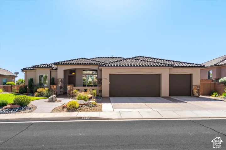 Stucco exterior with a tile roof, a two-car garage, and a single-car garage