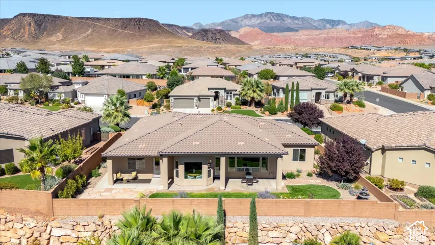 Tiled roof residence with an expansive backyard patio, mature landscaping, and an integrated water feature