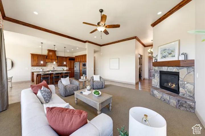 Open-concept living space featuring vaulted ceilings with exposed wood beams, a wood-finish ceiling fan, and recessed lighting