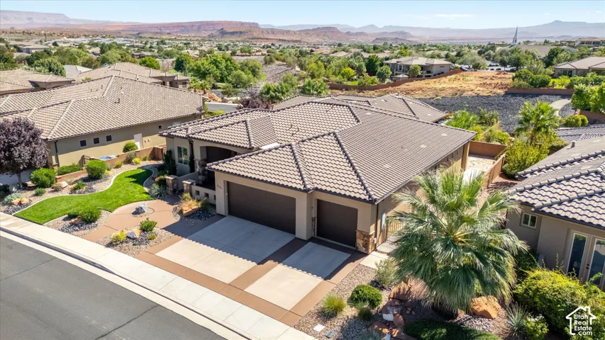 Stucco exterior with stone accents, tile roofing, and an attached two-car garage