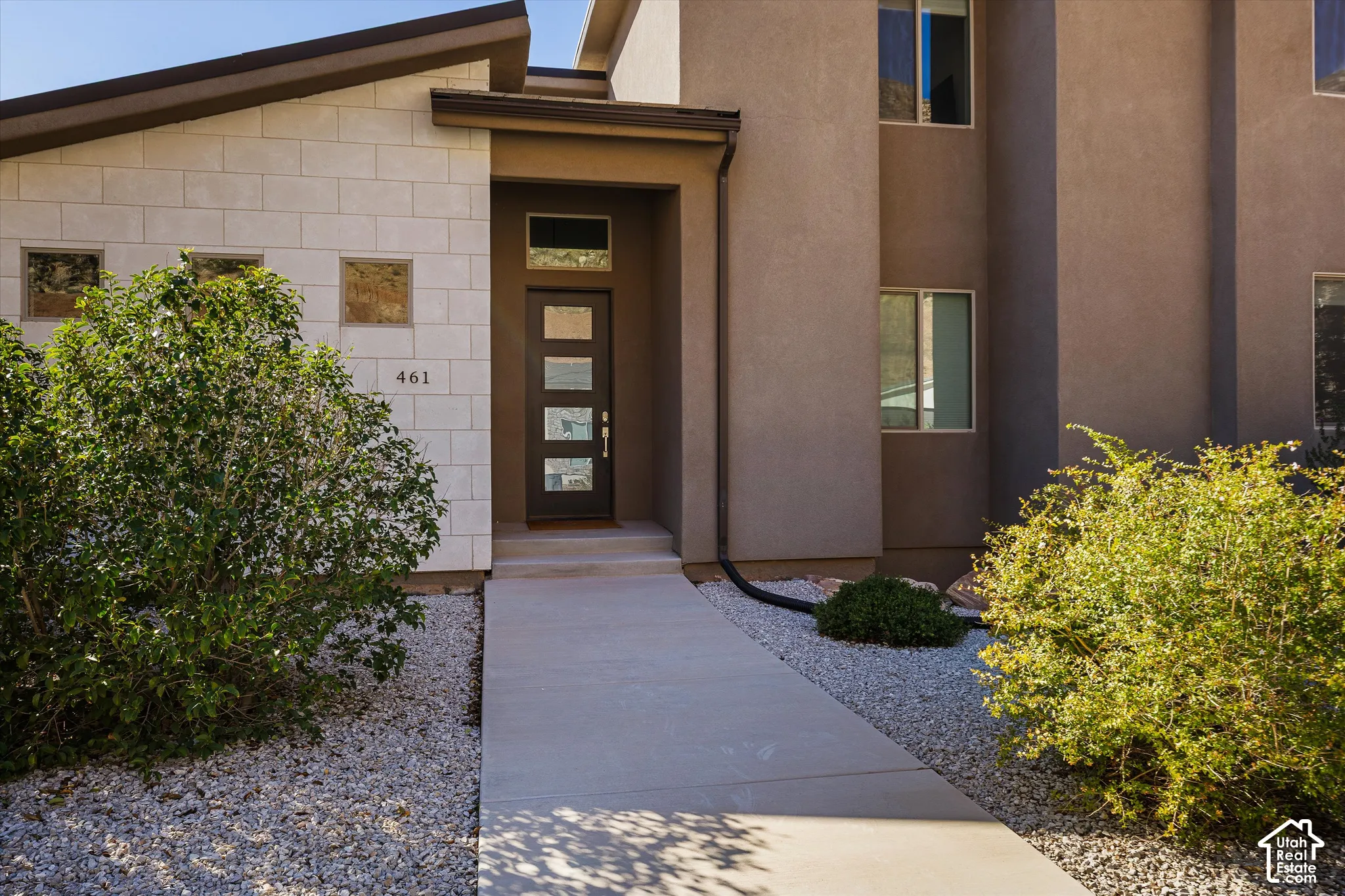Contemporary exterior with a stucco finish and stone accents
