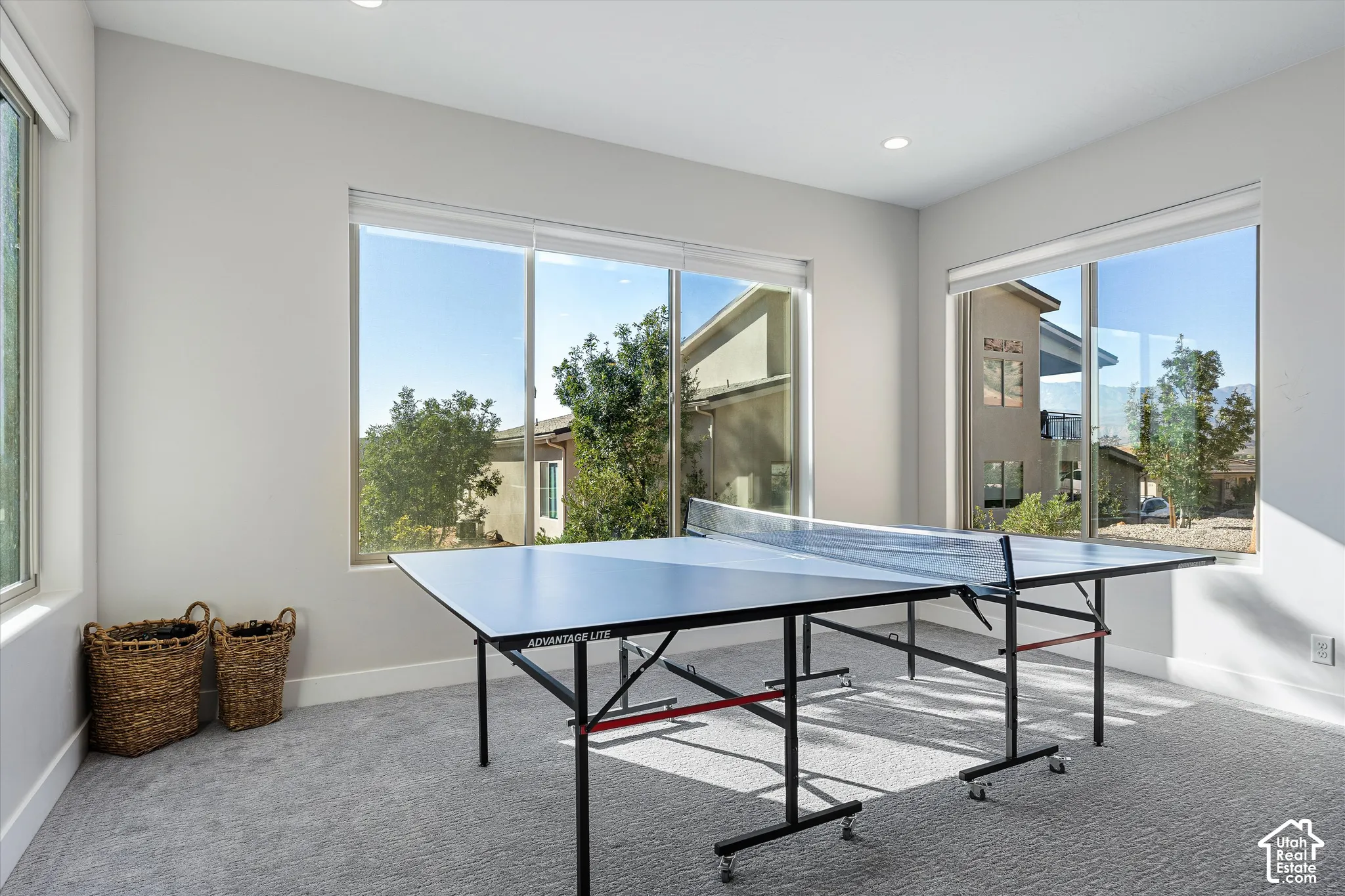 Recessed lighting, large windows, light gray walls, gray carpeting