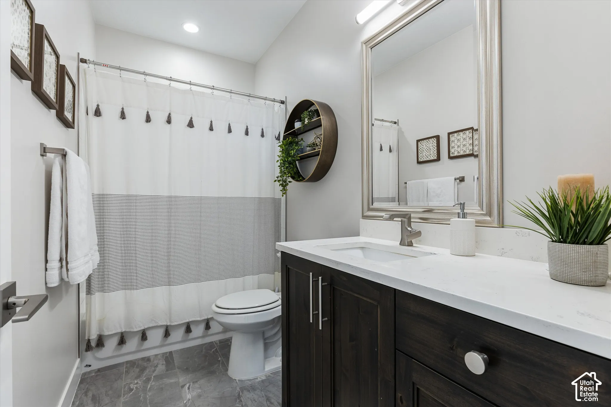Dark wood-finish vanity with white countertop, undermount sink, and brushed nickel hardware