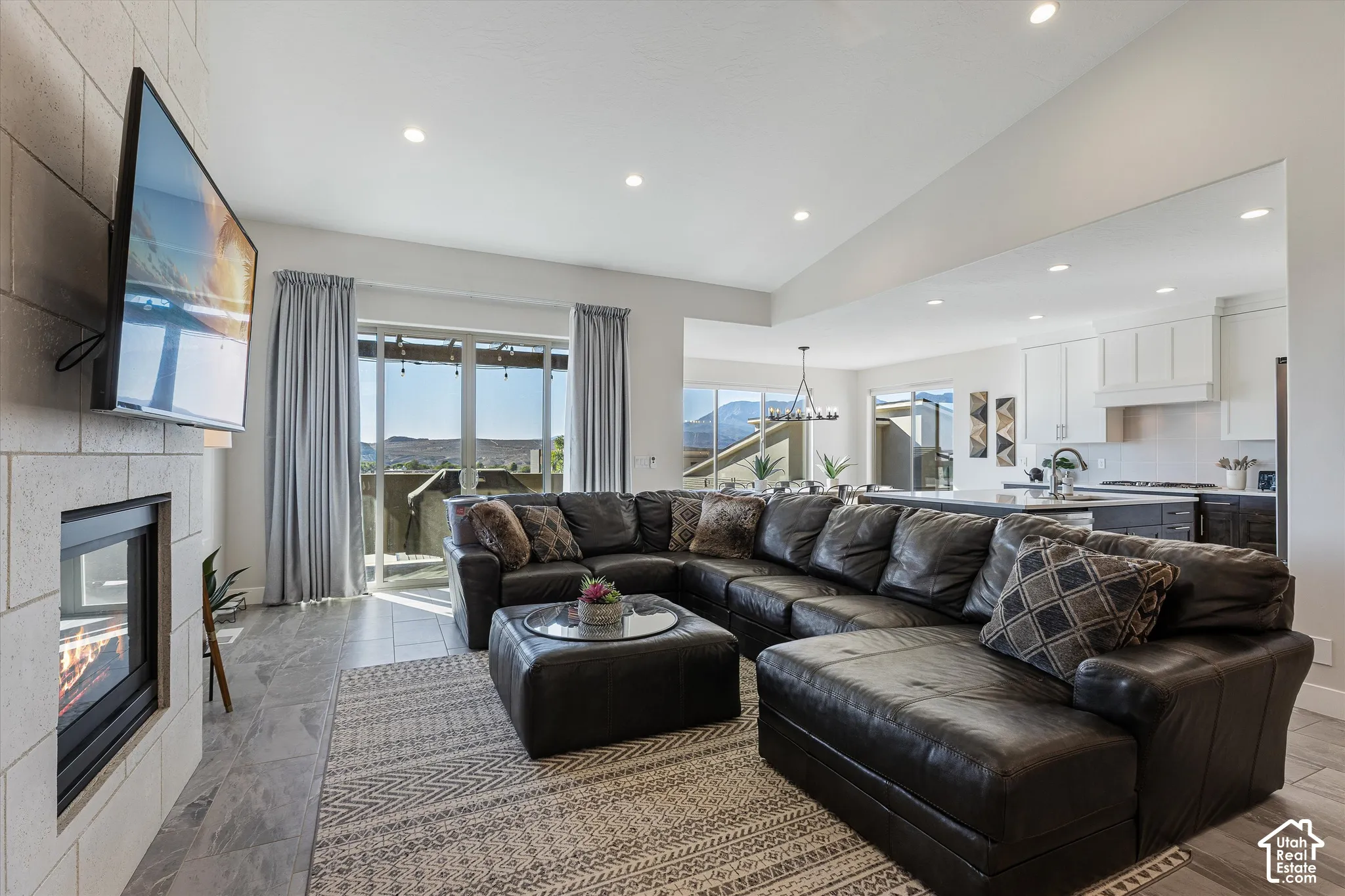 Living area with a stone-finish fireplace, recessed lighting, and tile flooring