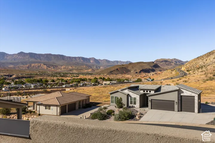 Contemporary exterior with an attached two-car garage, contrasting stone and stucco finishes, and desert landscaping