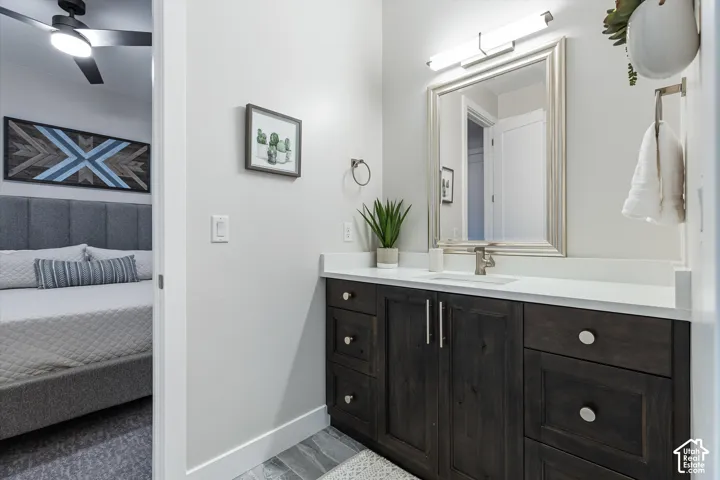 Vanity with a white countertop and dark wood-finish cabinetry, illuminated by an overhead light fixture
