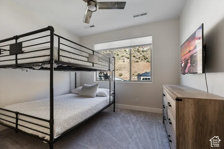 Recessed lighting, ceiling fan, window with roller shade, neutral wall paint, and gray carpet