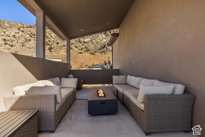 Covered outdoor patio with a built-in fire pit, recessed lighting, and substantial columns