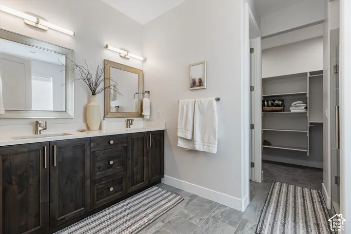 Dual vanity with wood-finish cabinetry, light countertops, and undermount sinks
