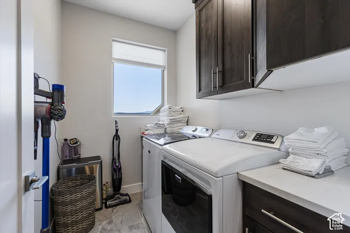 Laundry room featuring upper and lower cabinetry, a built-in countertop, and a window