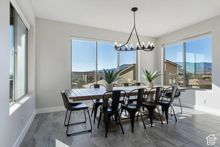 Spacious room featuring multiple windows, a modern chandelier, and tile flooring
