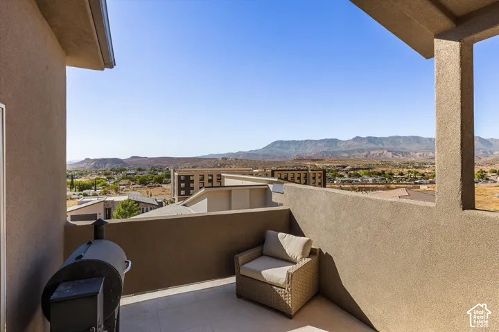 Terrace featuring a textured wall, tile flooring, and a panoramic mountain backdrop