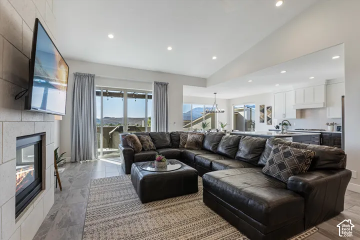 Living area with a stone-finish fireplace, recessed lighting, and tile flooring
