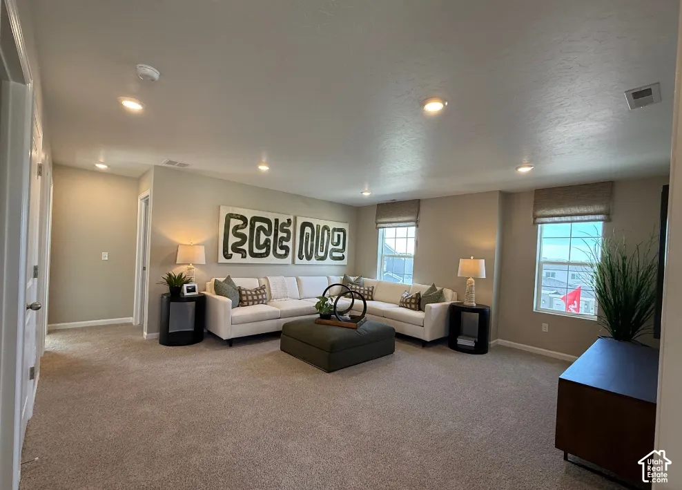 Loft 2. Picture from another model and for example only. Recessed lighting illuminates the carpeted living area with multiple windows featuring window treatments