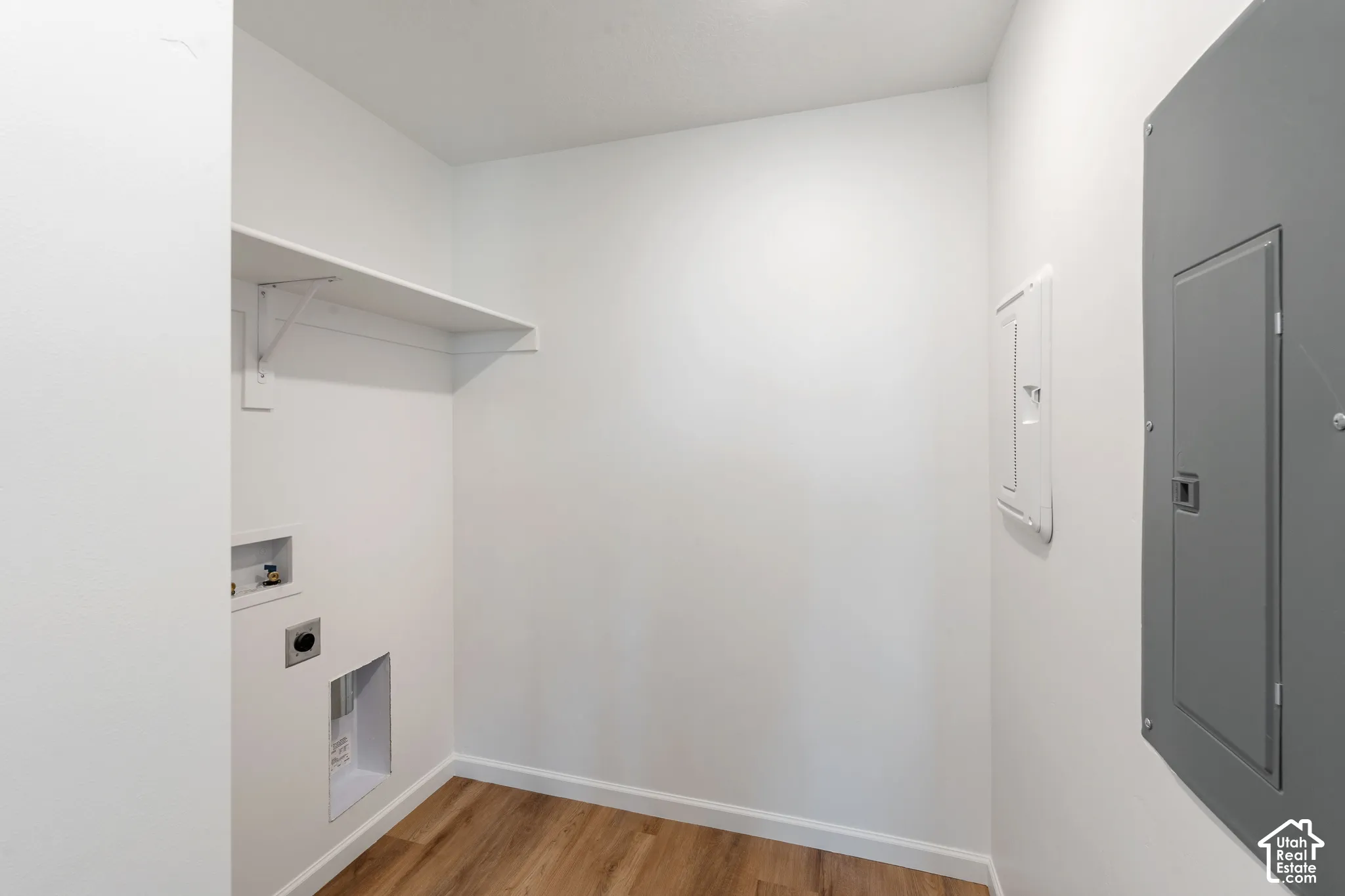 Picture from another model and for example only. Laundry room with wood-finish flooring and integrated shelving