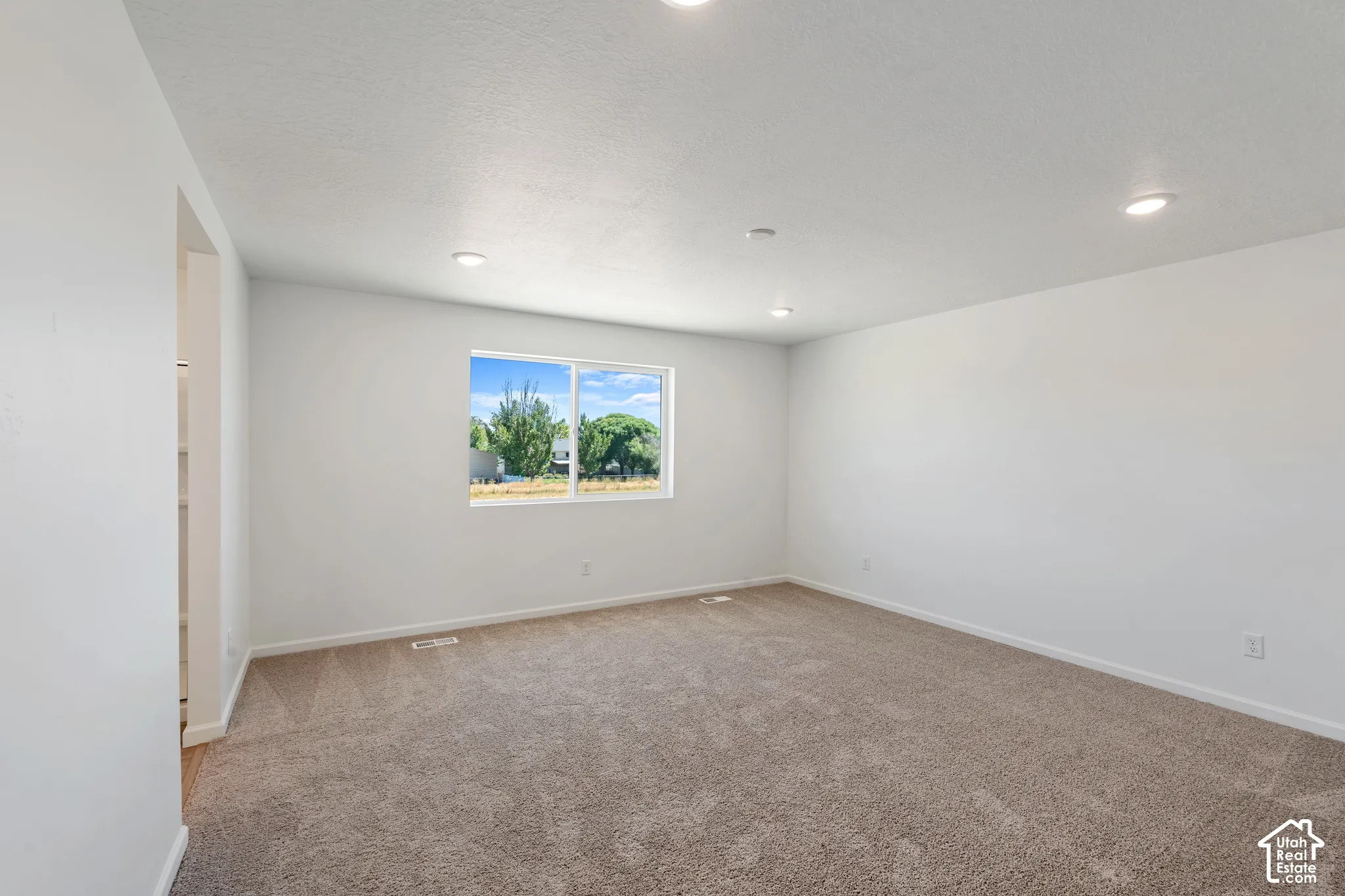 Picture from another model and for example only. Recessed ceiling lighting, a window with exterior scenery, light-toned carpeting, and a neutral wall color