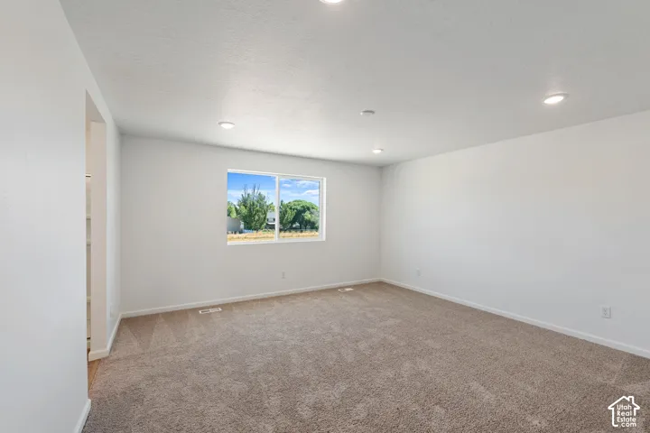 Picture from another model and for example only. Recessed ceiling lighting, a window with exterior scenery, light-toned carpeting, and a neutral wall color