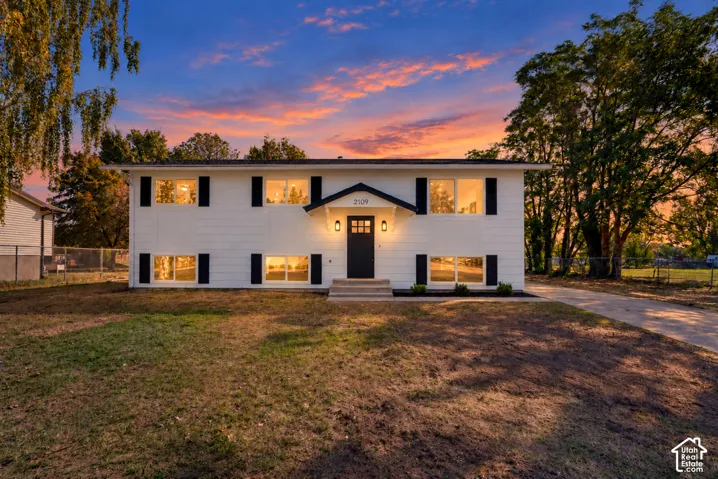 Two-story residence with white siding, black window shutters, and a dark entry door