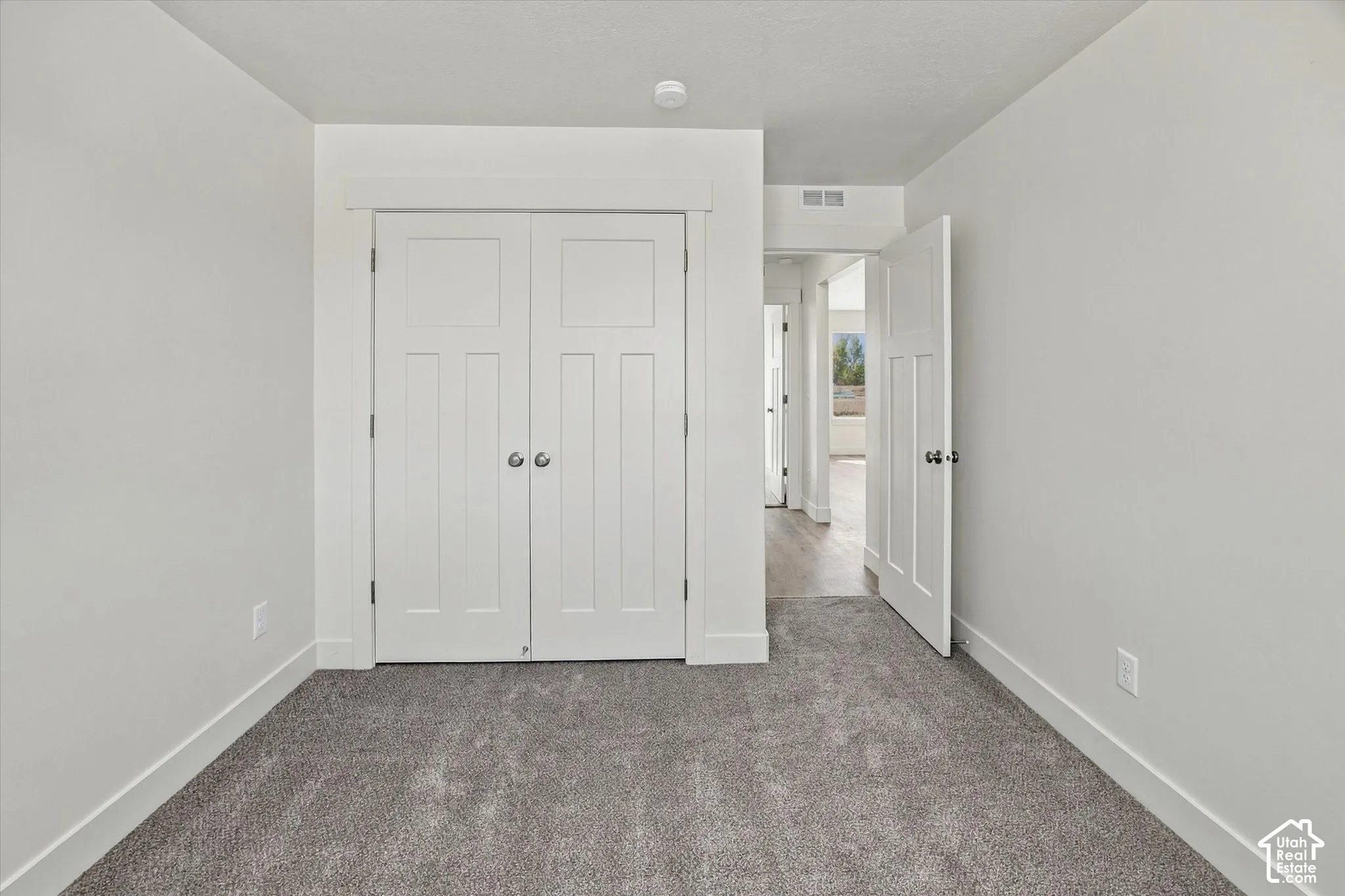 Plush gray carpeting, white walls, and white trim create a neutral palette