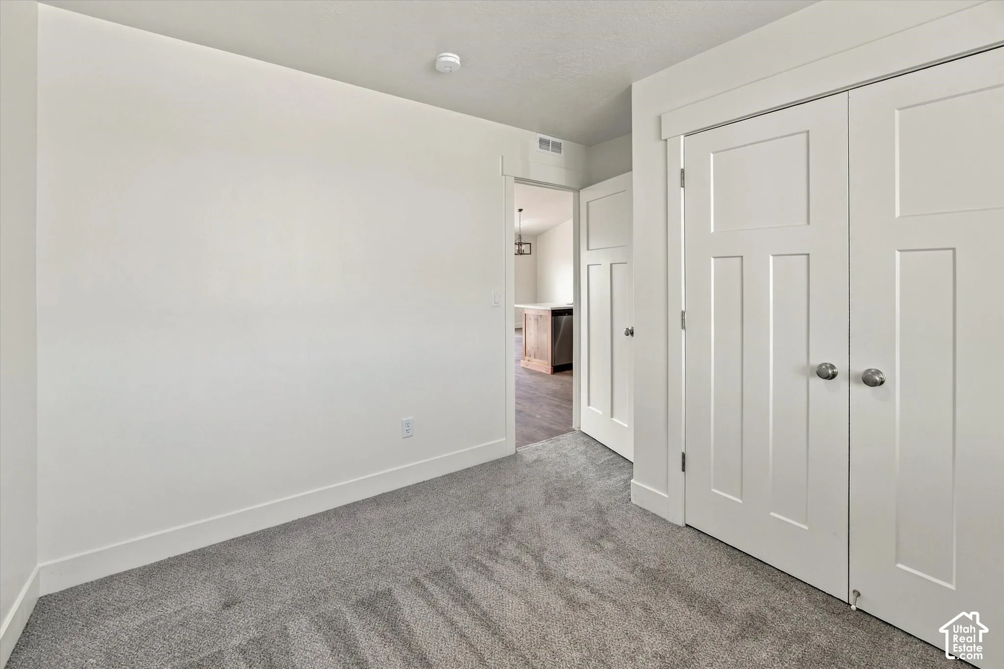 Plush gray carpet flooring, white painted walls, and white trim molding