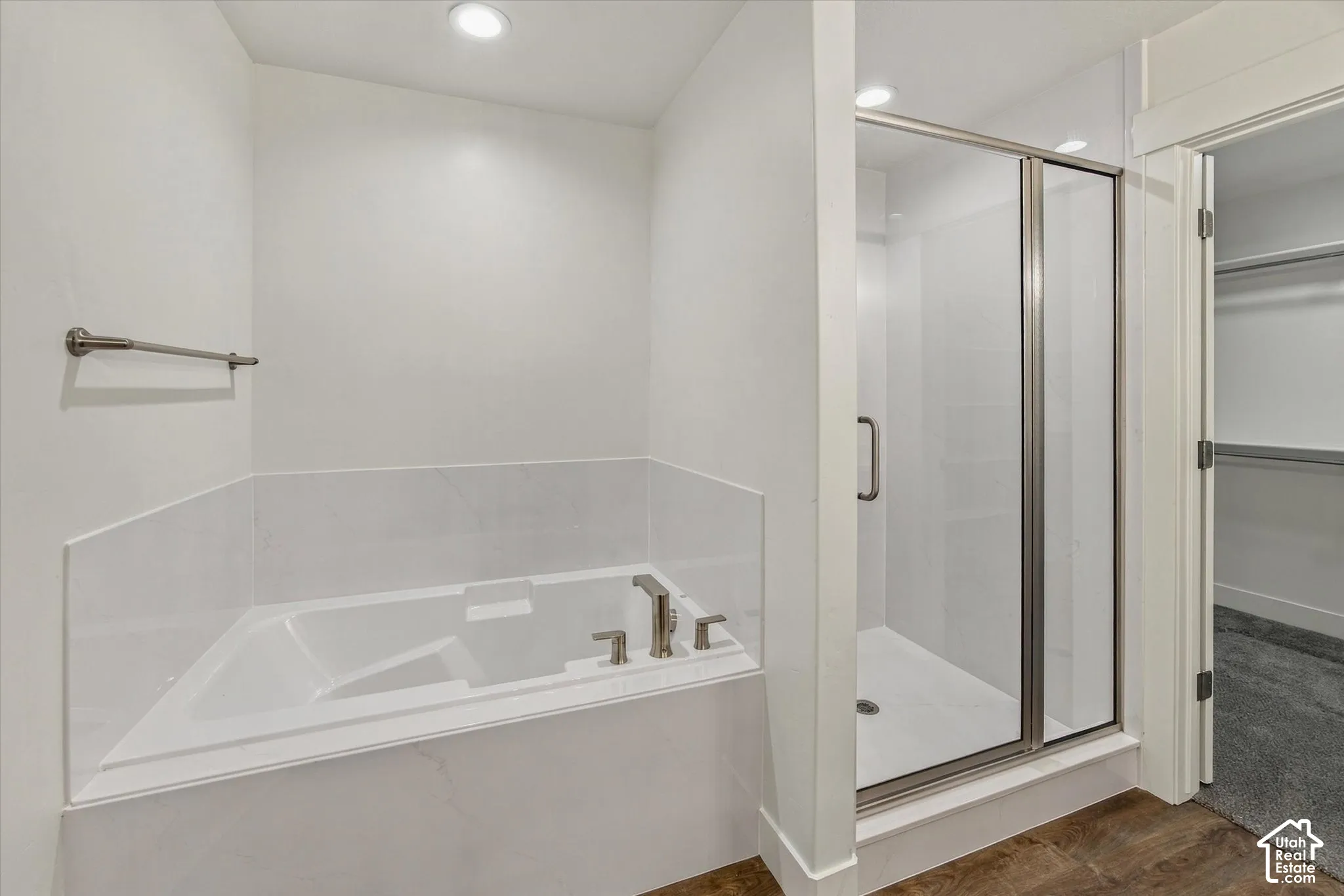 Built-in bathtub with tile surround, glass-enclosed shower, and recessed lighting
