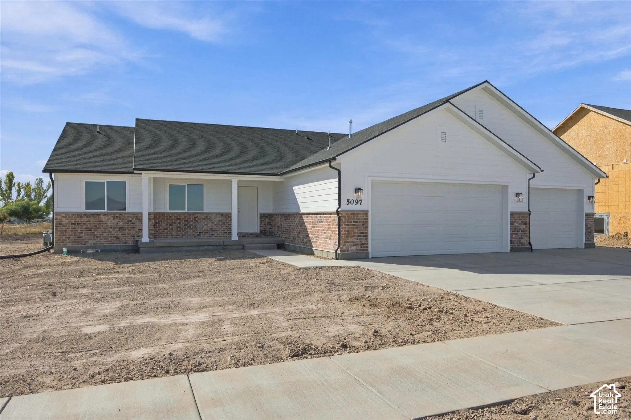 Ranch-style exterior with white siding and brick accents