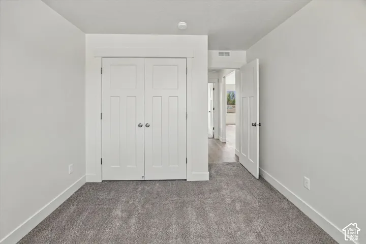 Plush gray carpeting, white walls, and white trim create a neutral palette