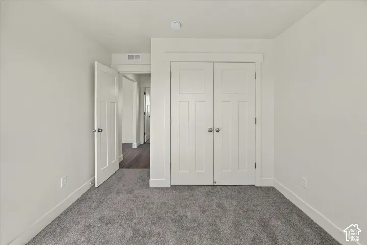 Plush gray carpeting, white painted walls, white paneled doors, and white door trim