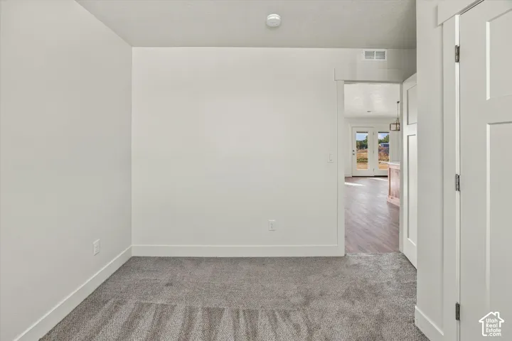 Neutral tone wall paint, gray carpeting, white trim, and white paneled interior doors