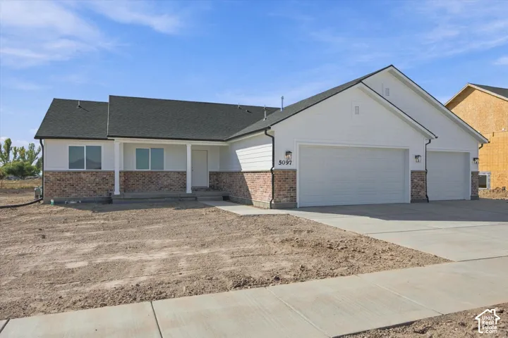 Ranch-style exterior with white siding and brick accents