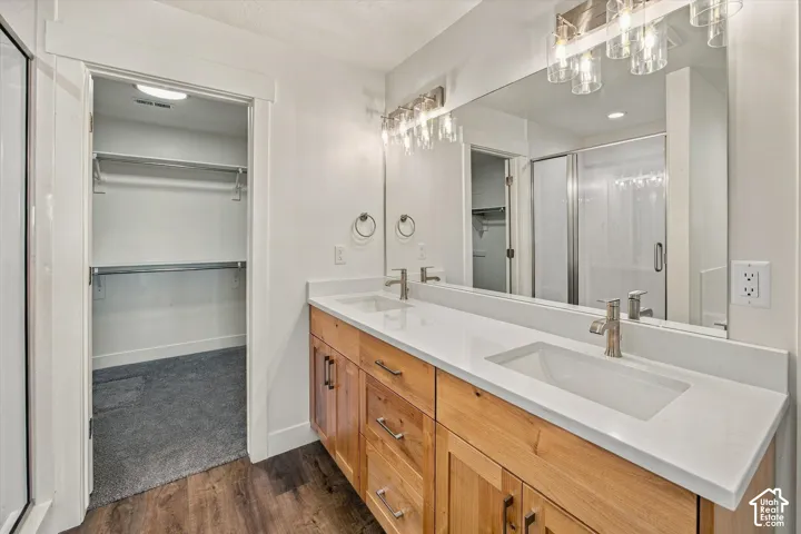 Dual vanity with white countertops, wood-finish cabinetry, and brushed nickel fixtures