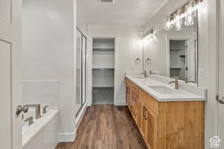 Double vanity with wood-finish cabinetry, white countertops, dual undermount sinks, and brushed nickel fixtures