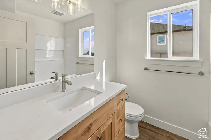 Wood-finish vanity with an integrated sink and brushed nickel faucet