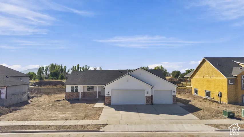 Contemporary ranch-style exterior with a two-car garage, concrete driveway, and brick accent siding
