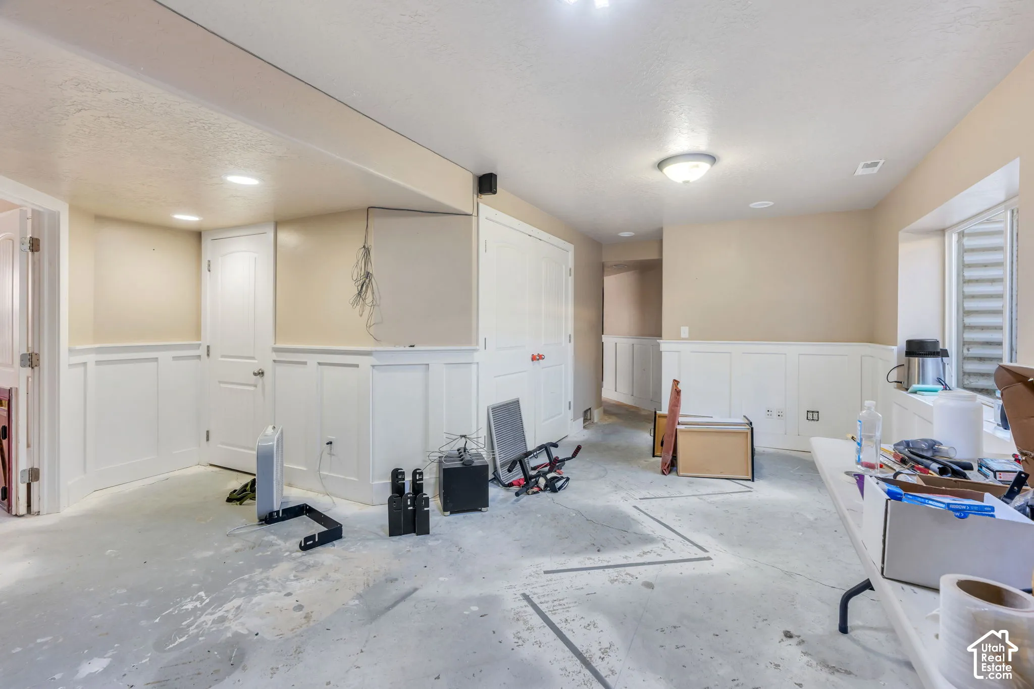 Finished lower level with wainscoting, recessed lighting, and a window well