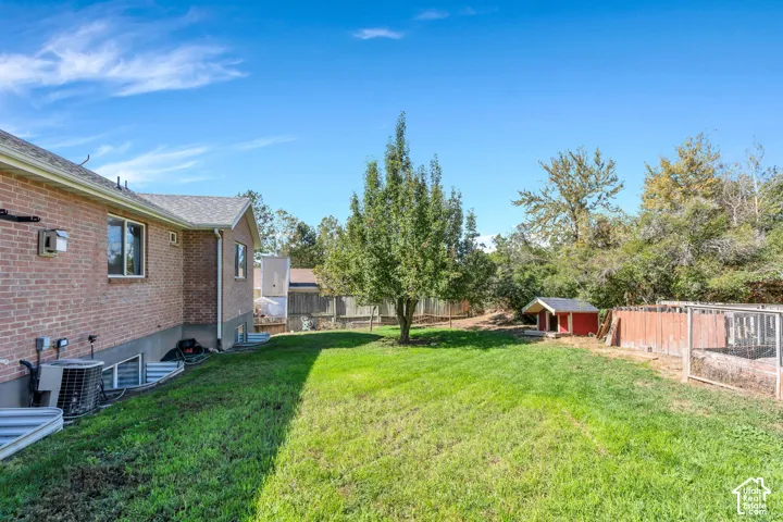 Expansive lawn with mature trees and a wood fence