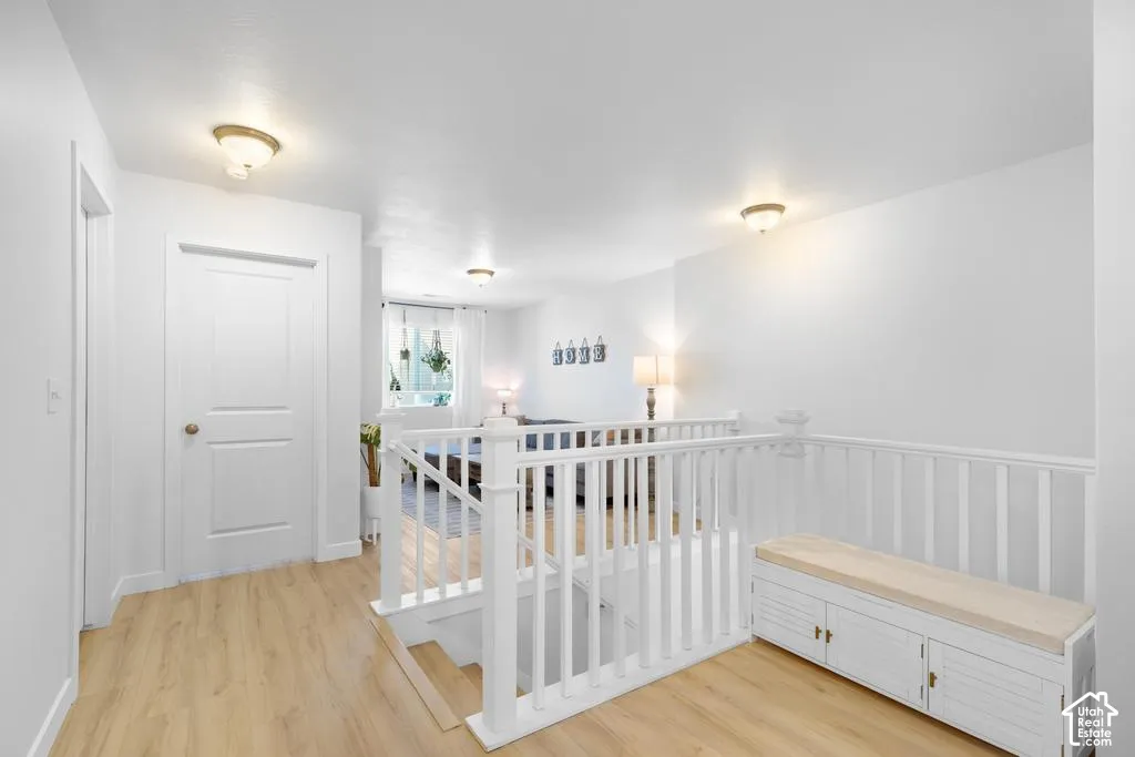 Wood-finish flooring throughout, white interior doors, and a white baluster staircase