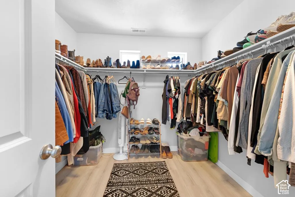 Walk-in closet with ample storage, integrated shelving, and multiple hanging rods