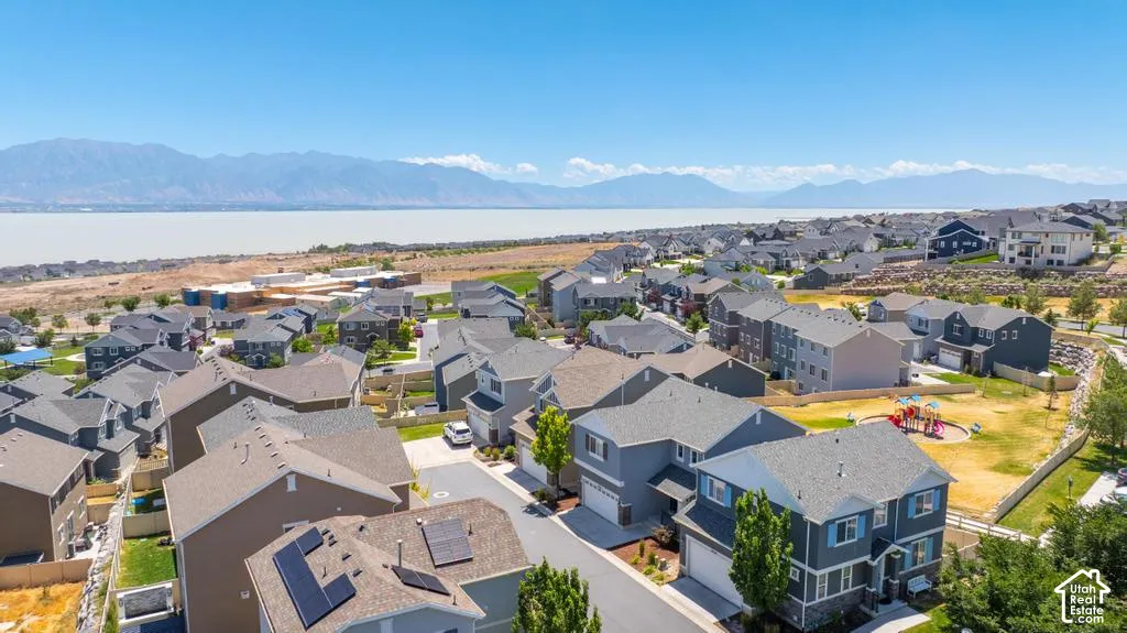 Residential community with a playground, mature trees, and mountainous scenery