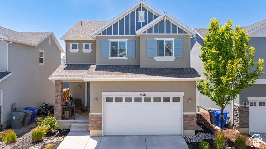 Two-story exterior with a two-car garage, stone accents, and a covered porch