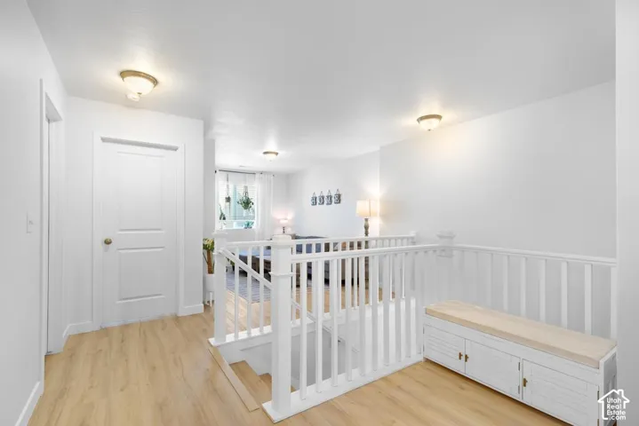 Wood-finish flooring throughout, white interior doors, and a white baluster staircase