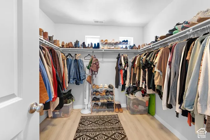 Walk-in closet with ample storage, integrated shelving, and multiple hanging rods