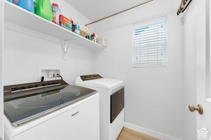 Laundry area with window, built-in shelving, and wood-finish flooring