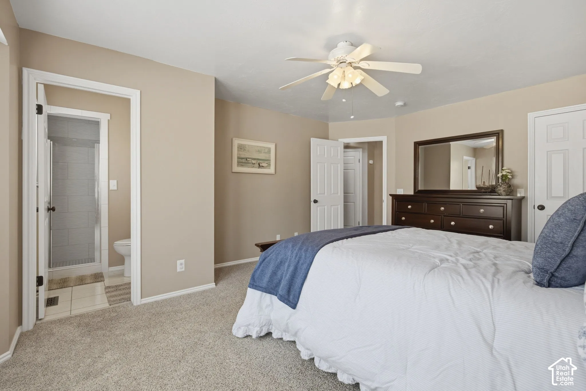 Neutral-toned walls, carpeted flooring, and a ceiling fan with integrated lighting