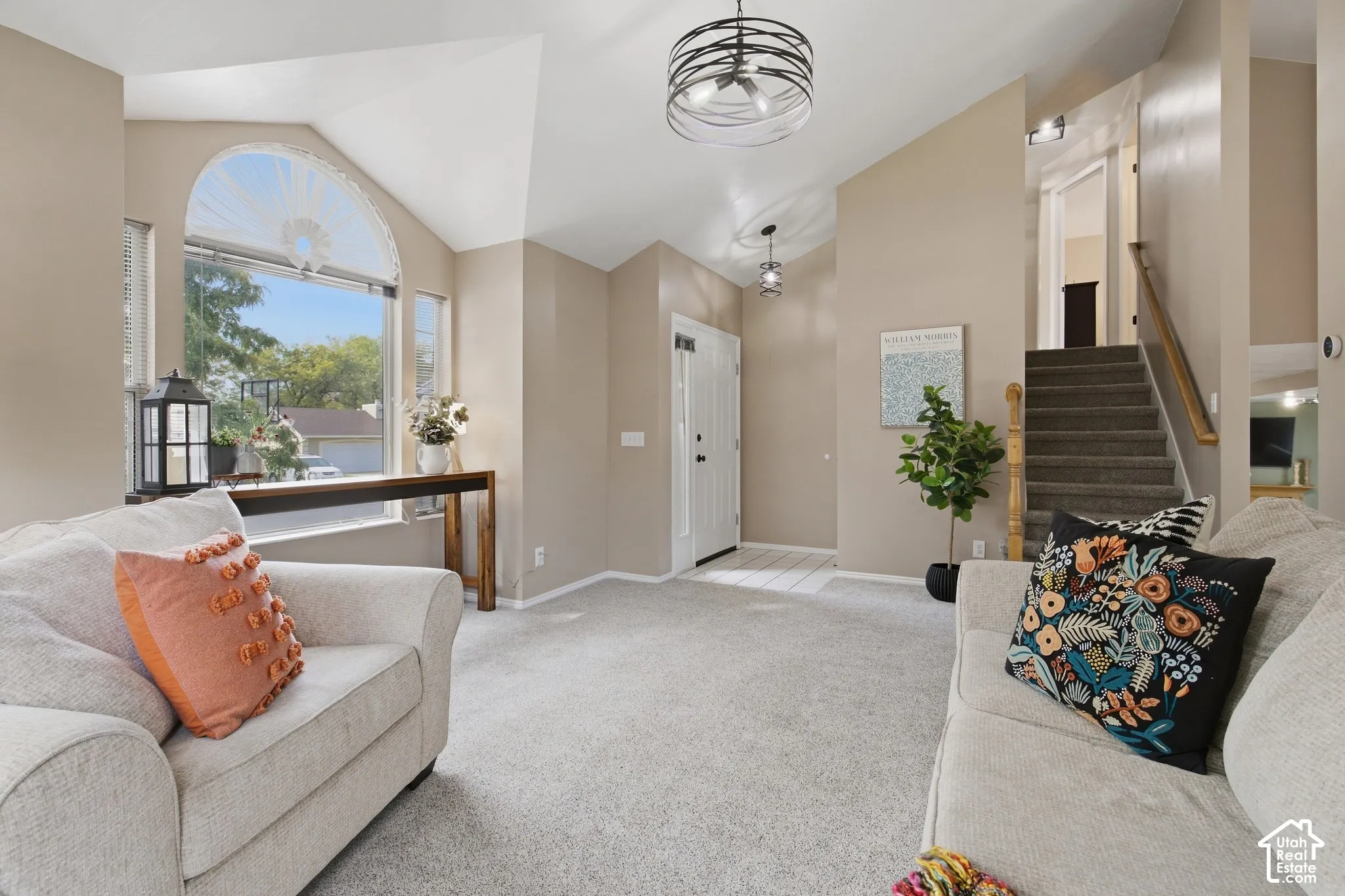Arched window with surrounding vertical windows, high vaulted ceiling, and recessed lighting